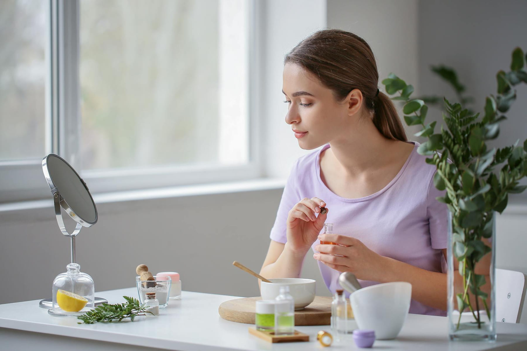 A young woman embraces self-care with natural cosmetics indoors. on Purely Polished