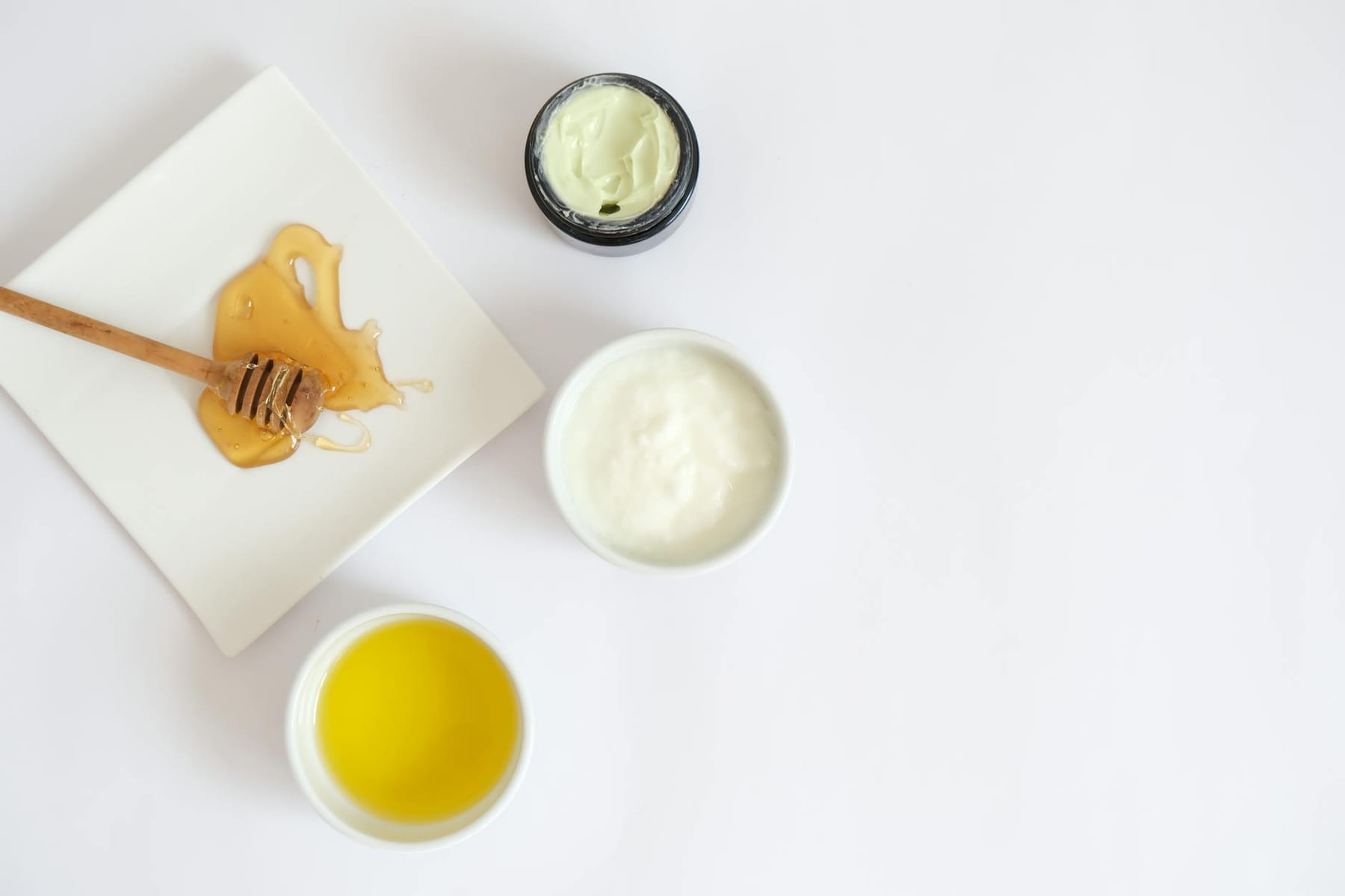 Flat lay image of honey, cream, oil, and natural ingredients for skincare. on Purely Polished