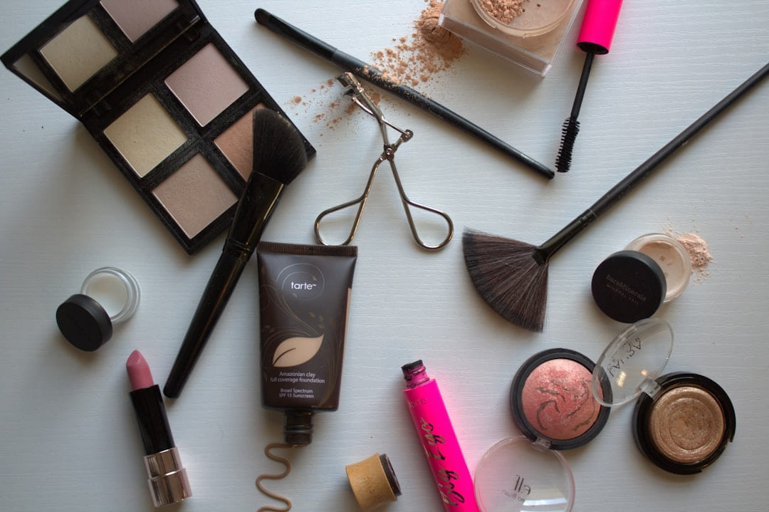 A variety of cosmetics and makeup products on a table on Purely Polished