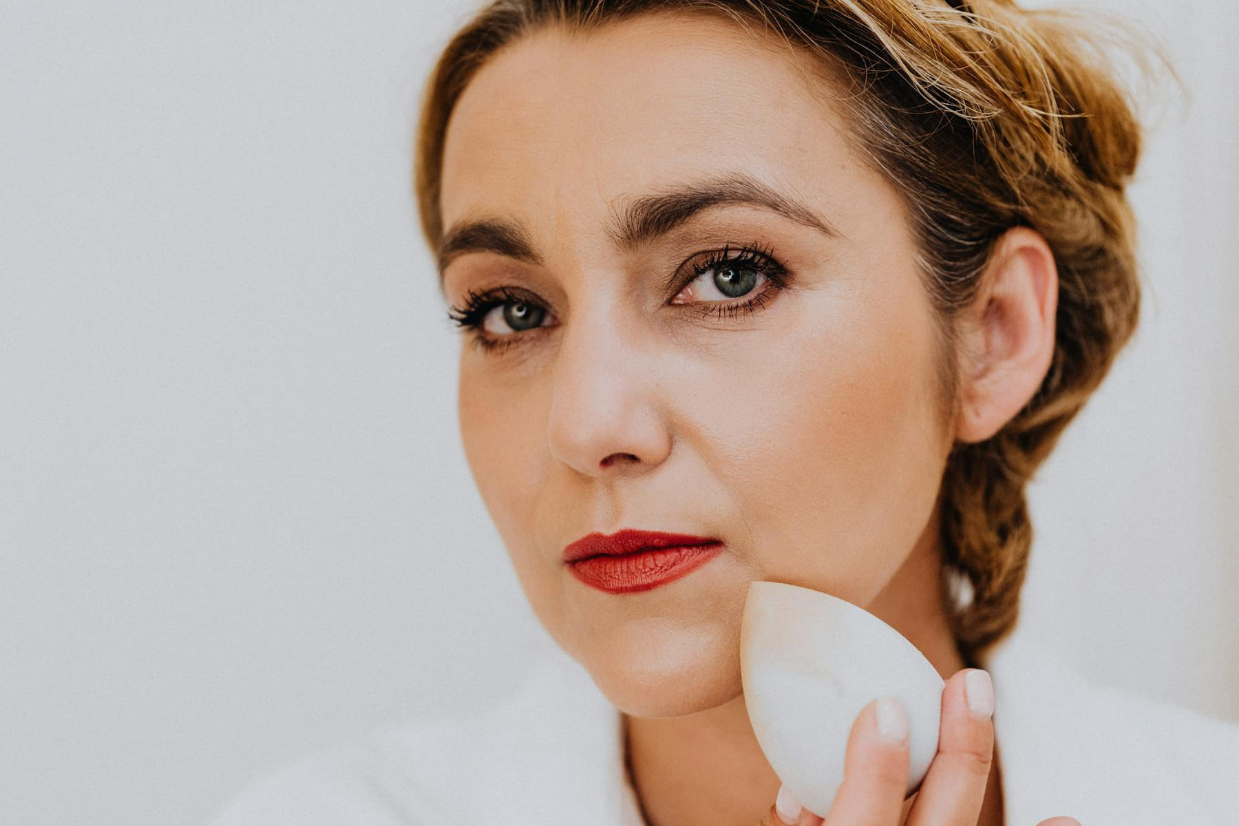 Close-up of a woman using a sponge for makeup application. Beauty and skincare concept. on Purely Polished
